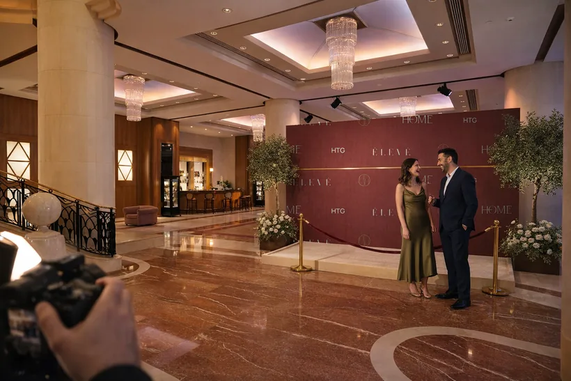 Logo photo wall — A burgundy step-and-repeat with the HR seal, ÉLEVÉ, Home Residence and HTG
